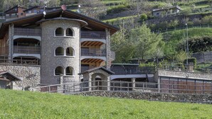 A multi-story stone building with balconies, a stone staircase, and a surrounding stone wall. - Eden View in Incudine (Monno)