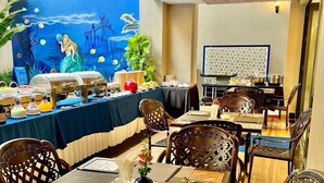 A dining area with a mural of a mermaid and sea creatures, wooden ceiling, and a buffet setup. - Sabina Luxury Boutique Hotel & Villa (Ho Chi Minh City)