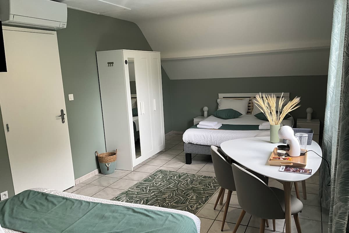 Ein gemütliches Schlafzimmer mit Bett, Schreibtisch mit Stuhl, Kleiderschrank und Nachttisch mit Lampe.