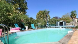 Una piscina rectangular rodeada por una terraza de madera.