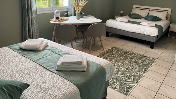 Un dormitorio con cama, escritorio y silla. Hay una ventana con cortinas, un cuadro en la pared y una alfombra en el suelo.