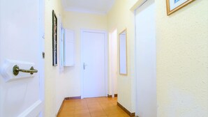 A hallway with a wooden floor, white walls, and a door at the end. - Private room with single bed, with terrace 200 m2. (Barcelona)