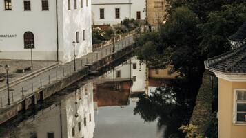 Ein Kanal mit Gebäuden, die sich im Wasser spiegeln, eine Brücke und ein Gebäude mit weißer Fassade.