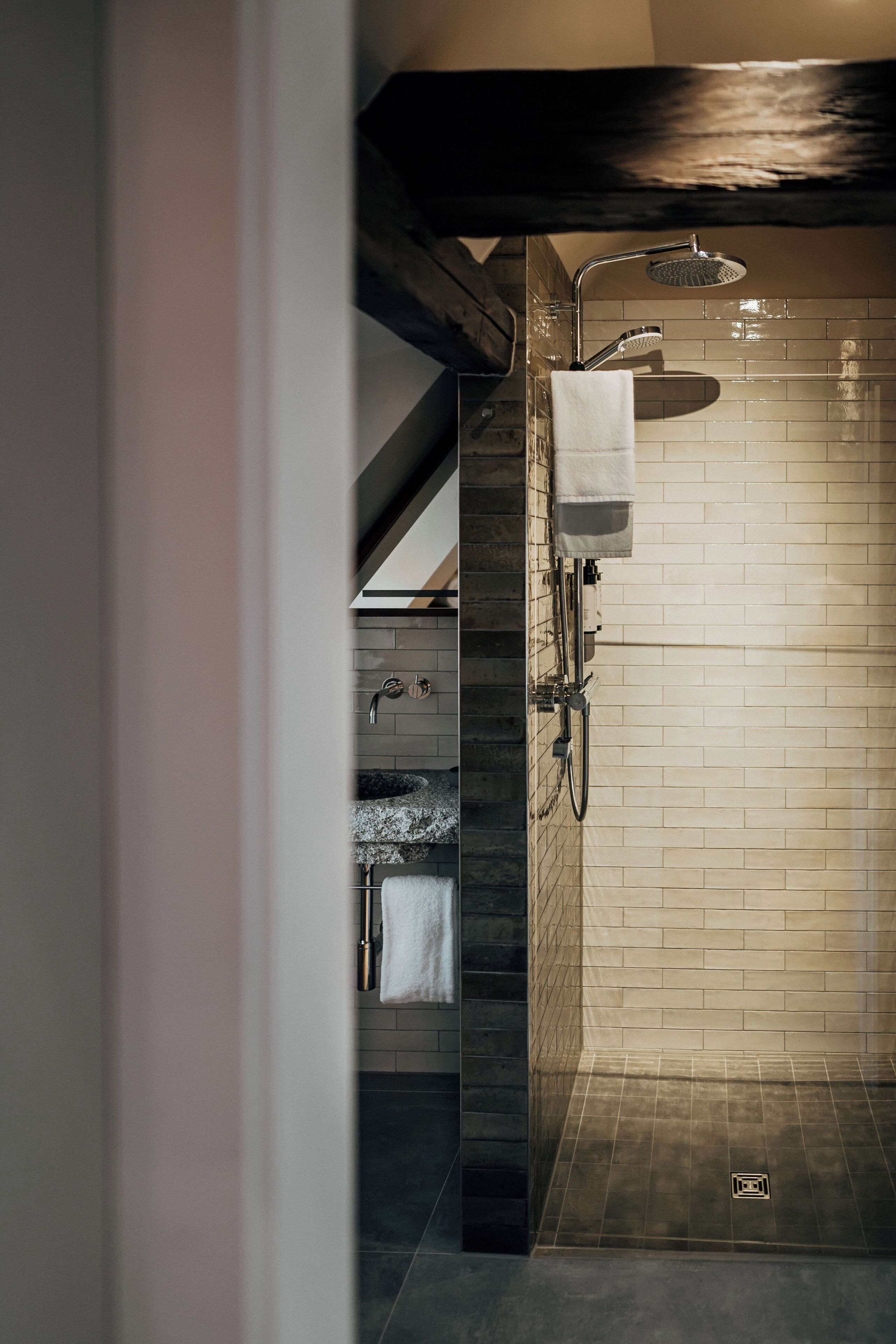 Un baño moderno con ducha, toallero y lavamanos.