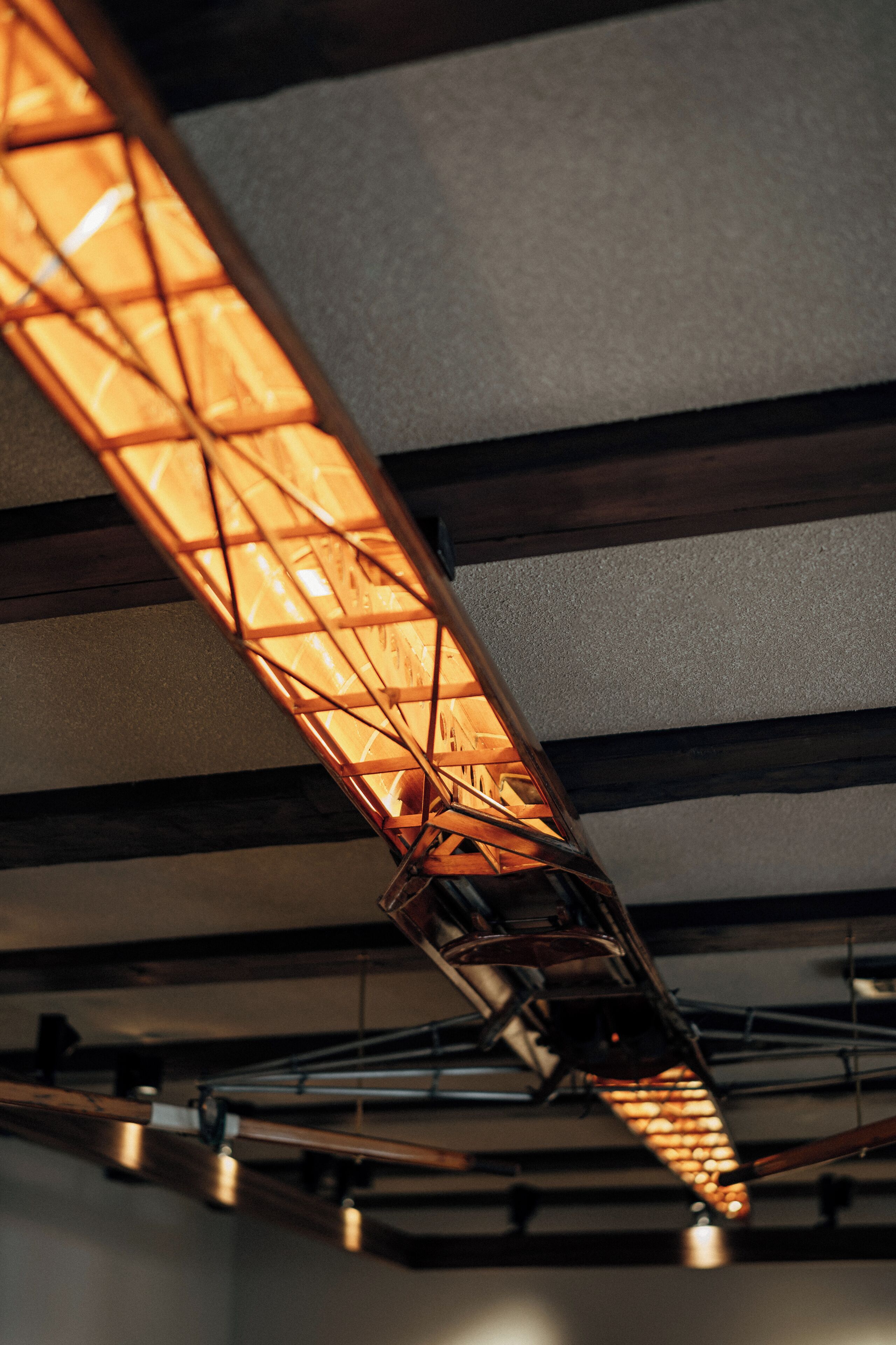 A modern ceiling with exposed beams and a geometric light fixture.