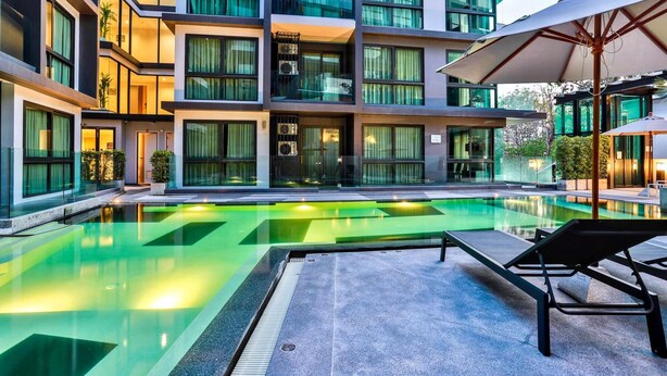 A modern hotel with a swimming pool, outdoor seating, and a multi-story building with balconies. - B305 - 1 Bedroom Serviced Apartment Pool View near Ao Nang Beach (Tambon Ao Nang)
