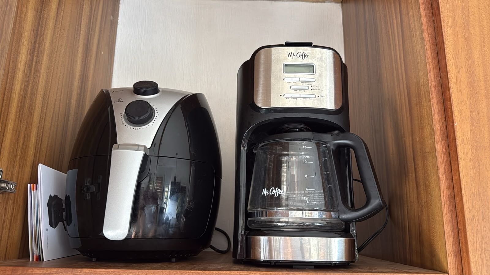 Eine Kaffeemaschine und ein Kaffeekännchen auf einer Holzwandregal.
