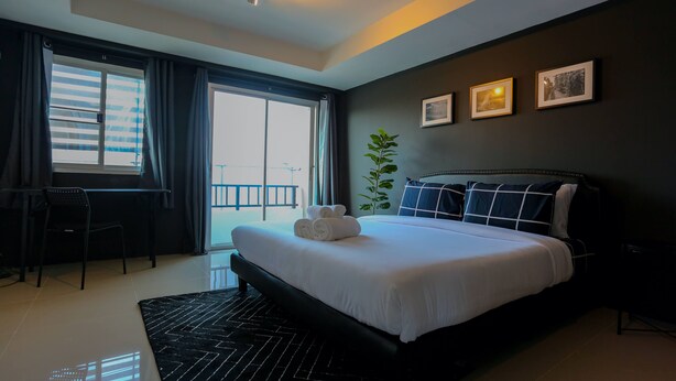 Habitación de hotel moderna con una cama grande, un escritorio y vistas a la ciudad.