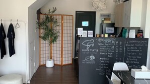 Un café moderno con suelo de madera, un menú en pizarra y un separador de ambientes tradicional japonés.