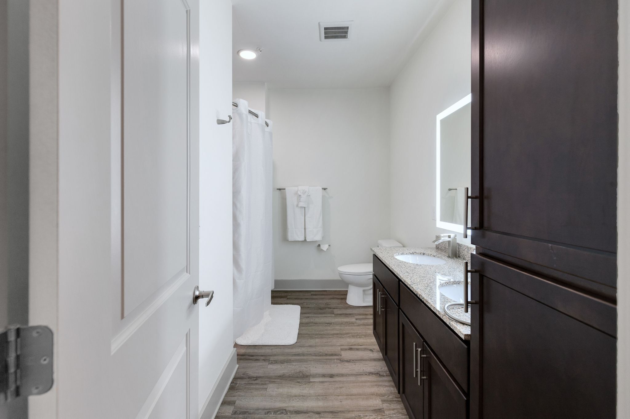 A modern bathroom with a shower, toilet, and sink.