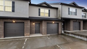 A row of townhouses with brick facades and dark garage doors.