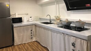 A modern kitchen with a built-in microwave, a stainless steel refrigerator, a sink, and a stove. - 3 Bedroom Villa Din Daeng BKK (Bangkok)