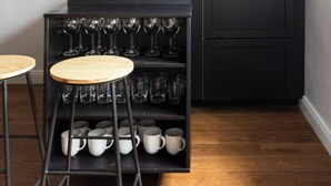 A compact kitchen with a black countertop, a built-in microwave, and a wine rack. - Louly Trevi Fountain 4 Bedroom Luxury Apartment (Roma)