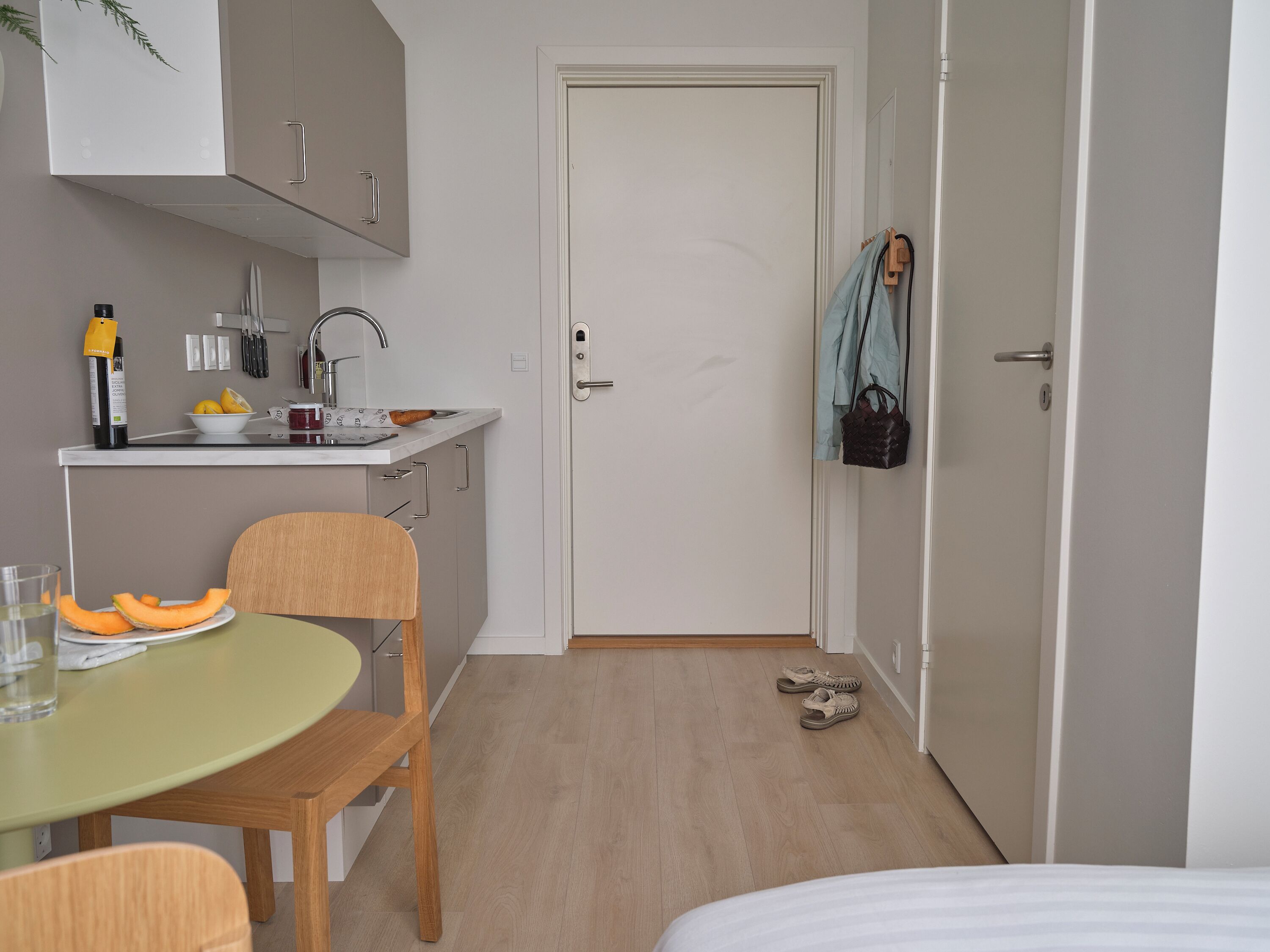 A compact kitchen with a dining table, chairs, and a small countertop with a sink.