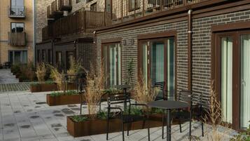 A courtyard with outdoor seating, brick walls, and balconies.