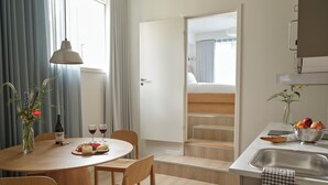 Una cocina moderna con comedor, muebles de madera y vista al dormitorio.