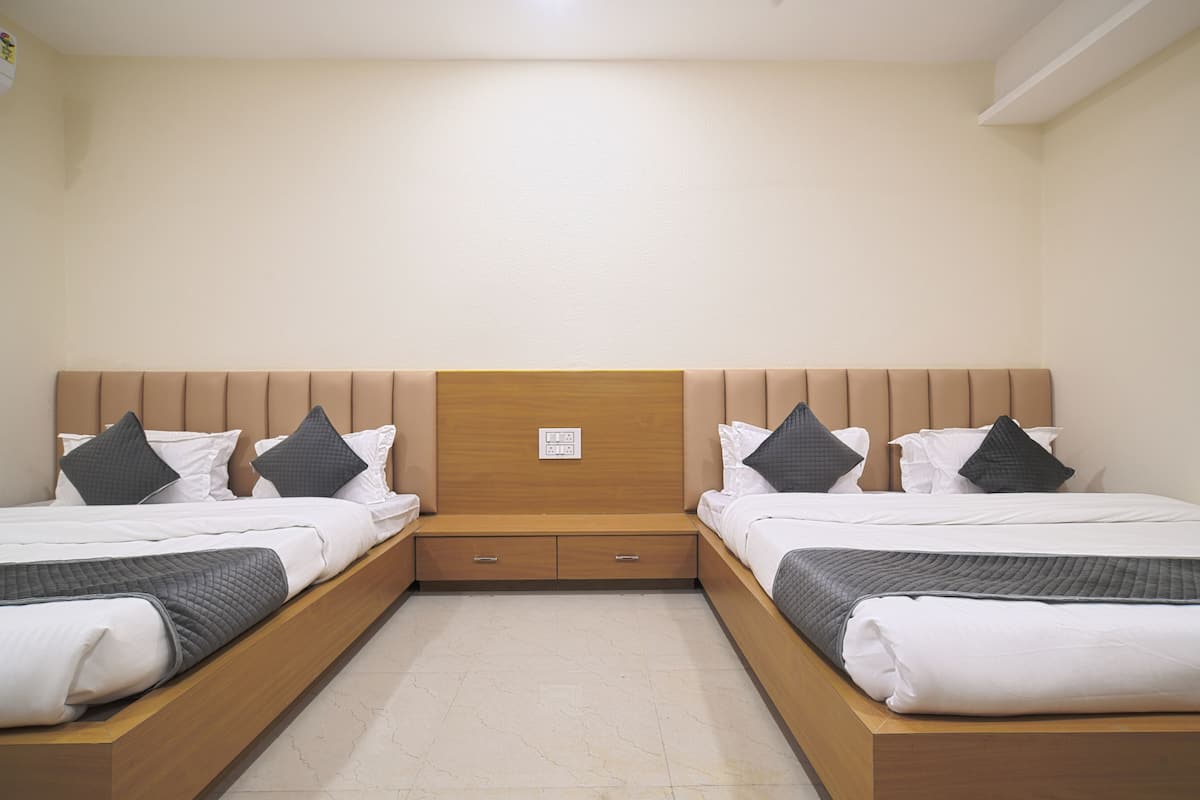 A double bed with a wooden headboard, two bedside tables, and a small drawer unit.