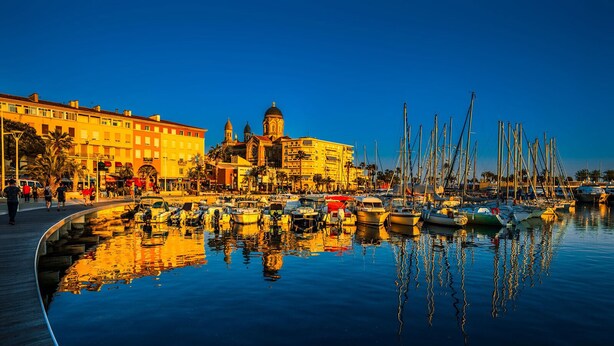 A marina with boats docked, a prominent building with a dome, and a waterfront promenade. - Location vue mer Saint Raphaël (Saint-Raphaël)