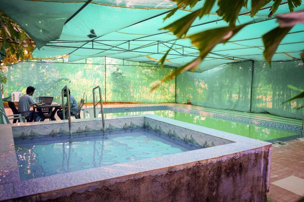 Una piscina interior con borde de azulejos y detalles de piedra.