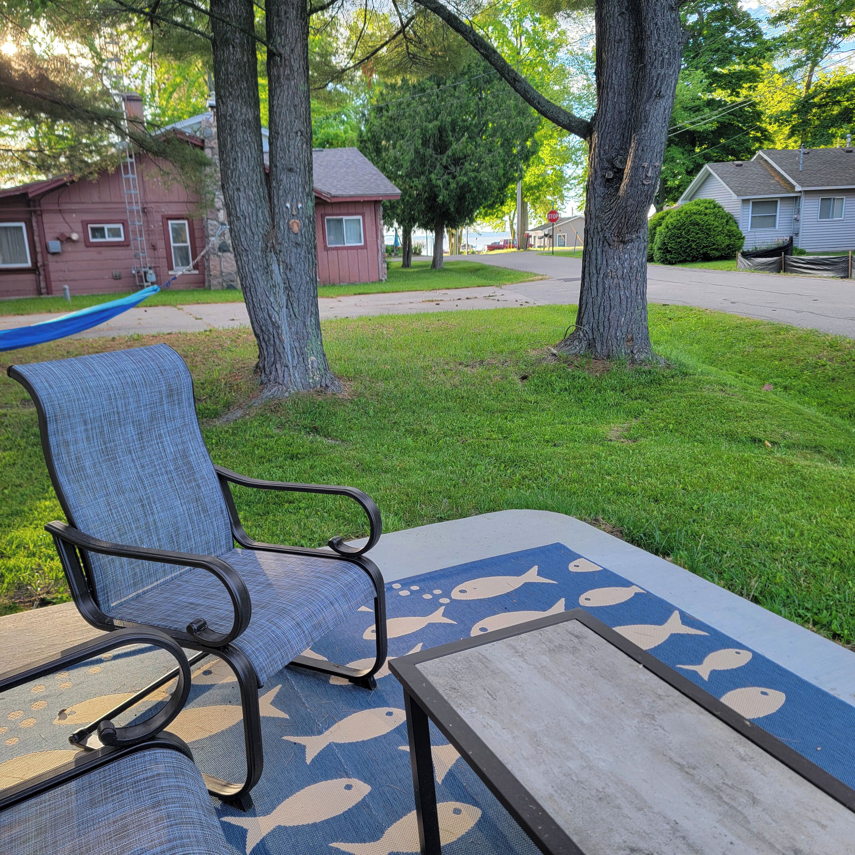A patio with a blue chair and a table with a fish pattern.