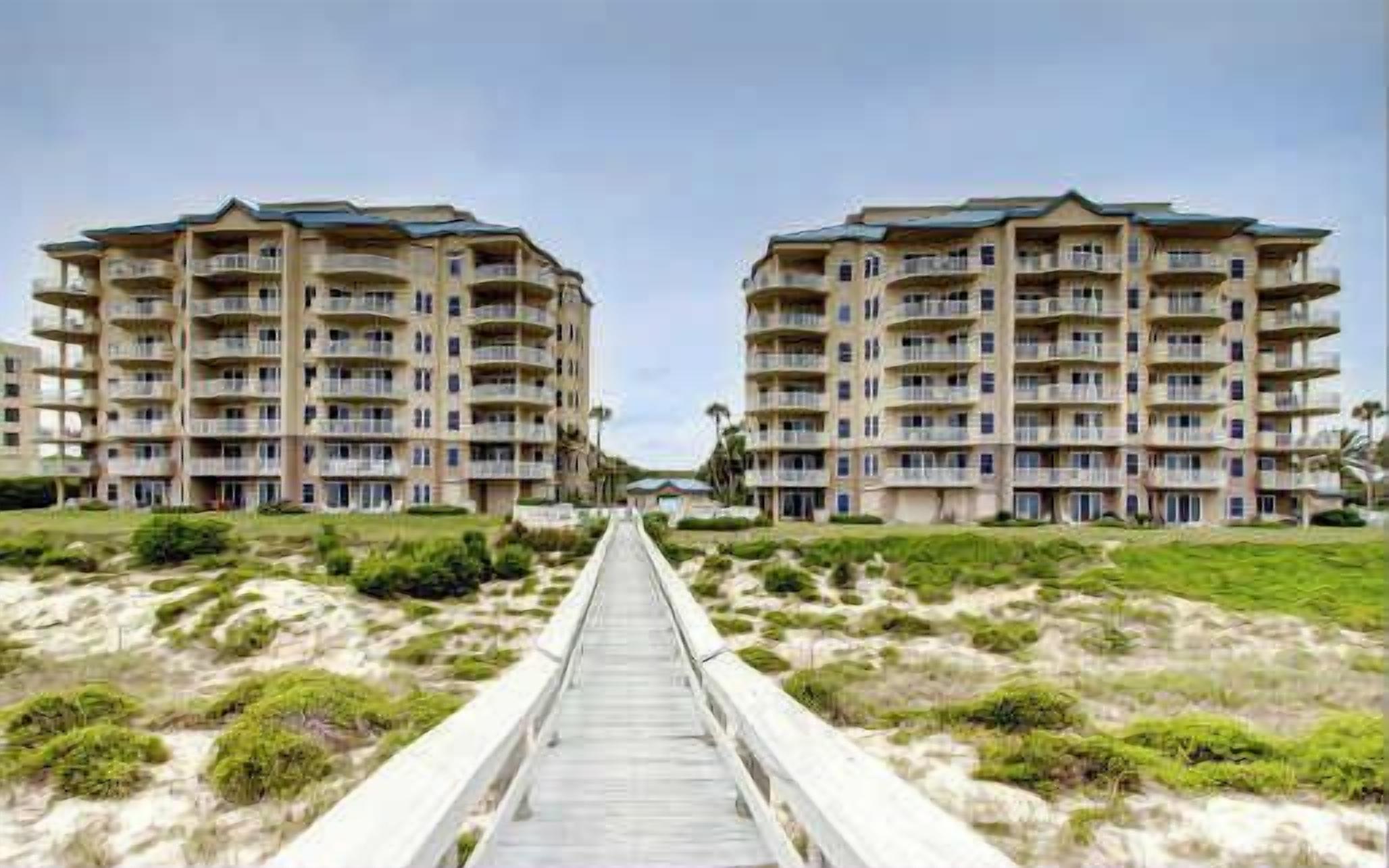 Een strandhotel met een centrale looppad naar de ingang.