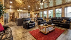 A spacious living room with leather sofas, a wooden coffee table, and a red rug. - Mountain Views and City Lights- Convenient to Attractions-Hot Tub Game Tables (Pigeon Forge)