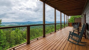 A wooden deck with a view of a mountainous landscape. - Mountain Views and City Lights- Convenient to Attractions-Hot Tub Game Tables (Pigeon Forge)