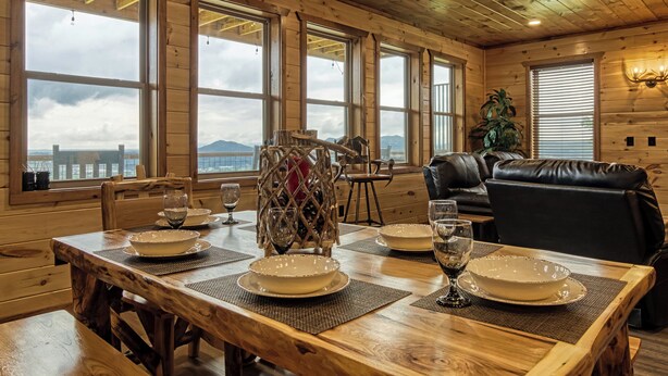 A wooden dining table set with plates, glasses, and a decorative centerpiece. - Mountain Views and City Lights- Convenient to Attractions-Hot Tub Game Tables (Pigeon Forge)