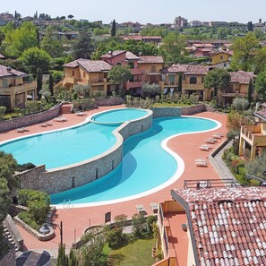 Relax by the resort's large, winding pool surrounded by a deck and lush greenery.