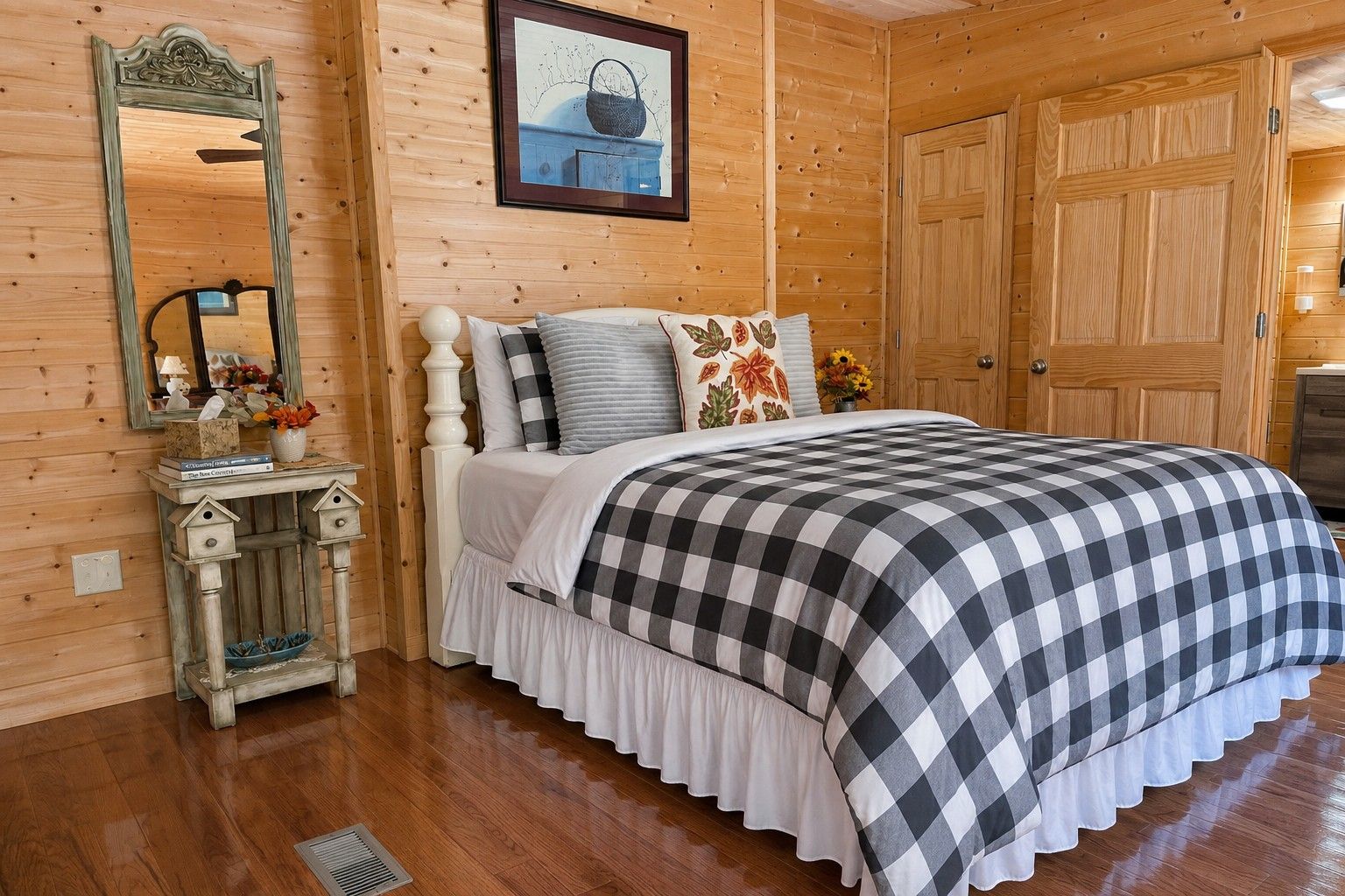 A wooden-paneled room with a bed, dresser, and a mirror.
