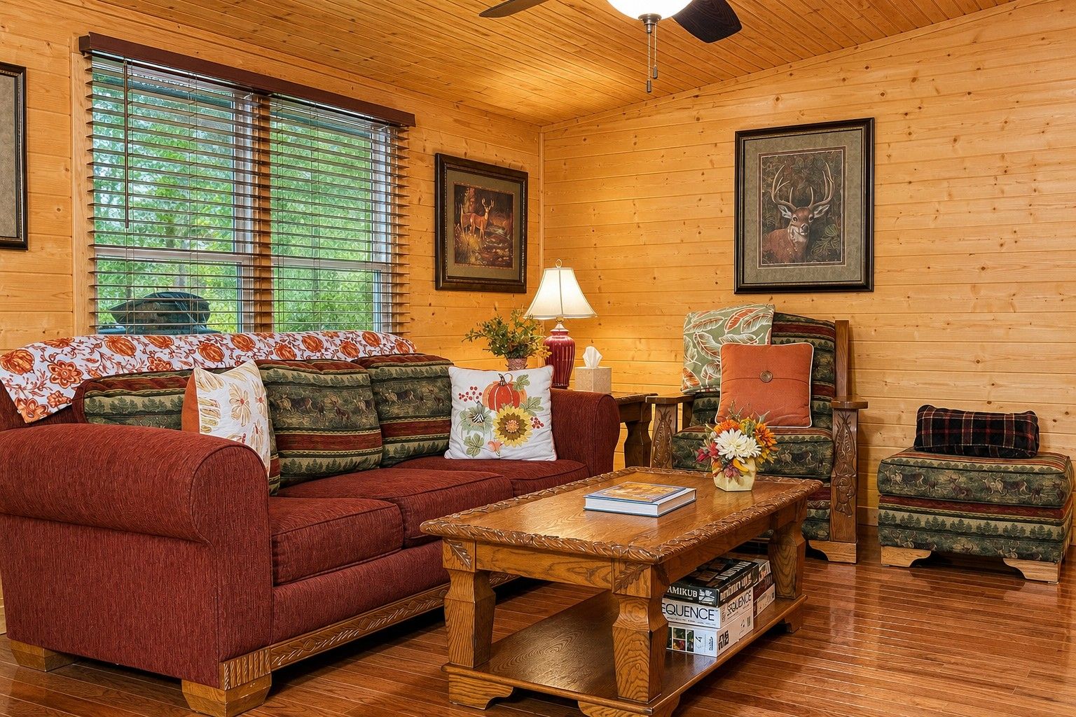 Un acogedor interior de cabaña con un sofá rojo, una mesa de centro de madera y una chimenea.