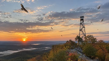 Una estructura en forma de torre con vistas panorámicas de un valle y el atardecer.