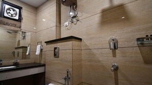 Un baño moderno con un espejo grande, un inodoro, un lavabo y una zona de ducha.