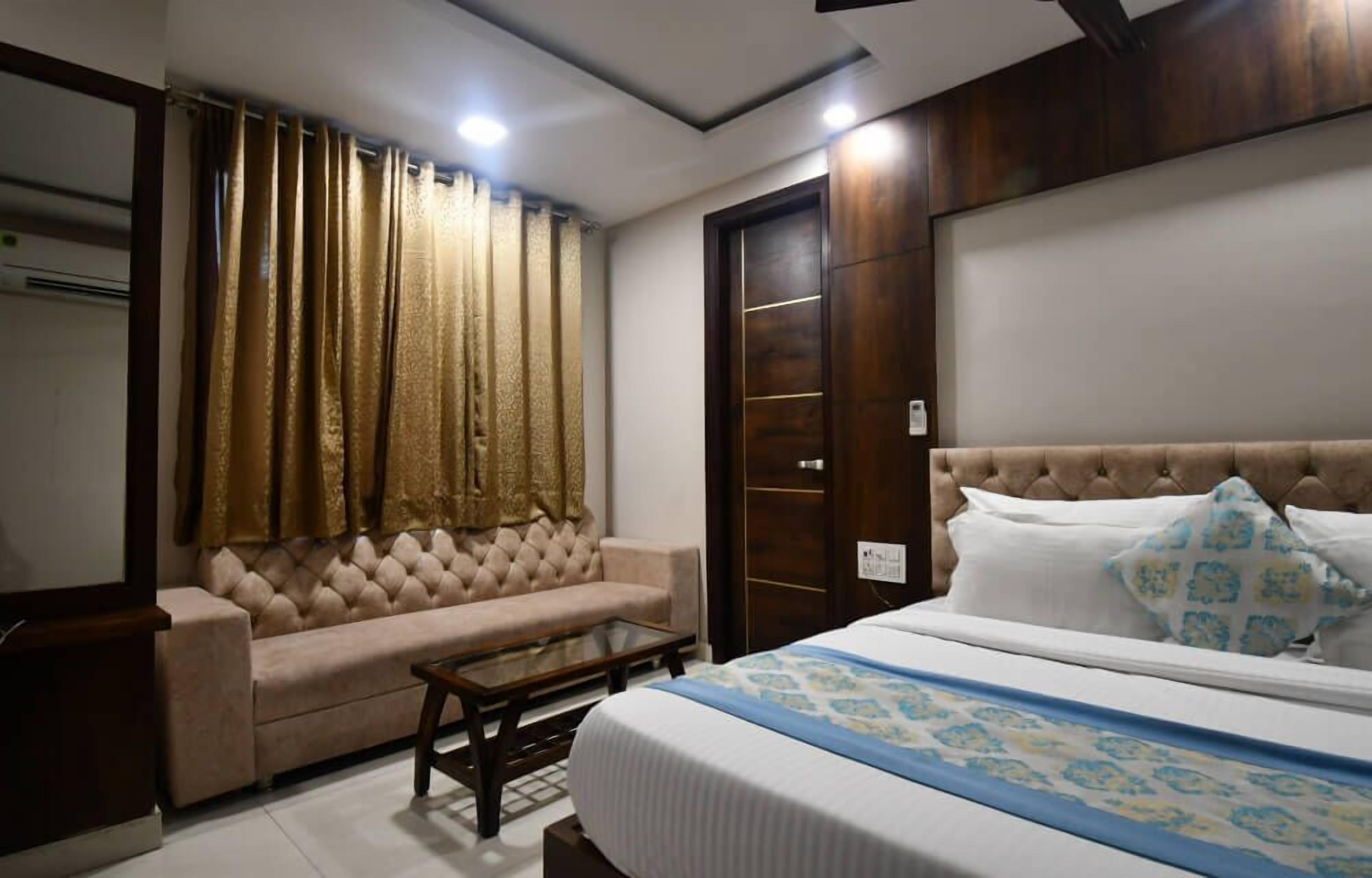 A bedroom with a bed, a sofa, a coffee table, and a wardrobe.