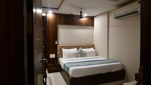 Un dormitorio con una cama grande, ventilador de techo y aire acondicionado.
