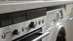 Una cocina con horno de acero inoxidable y microondas.
