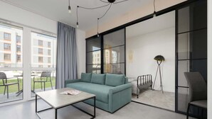 Un salon moderne avec un canapé, une table basse et un lampadaire.