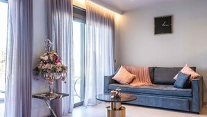 A modern living room with a sofa, a coffee table, and a decorative vase. - La Rêve Luxury Apartments (Hersonissos)