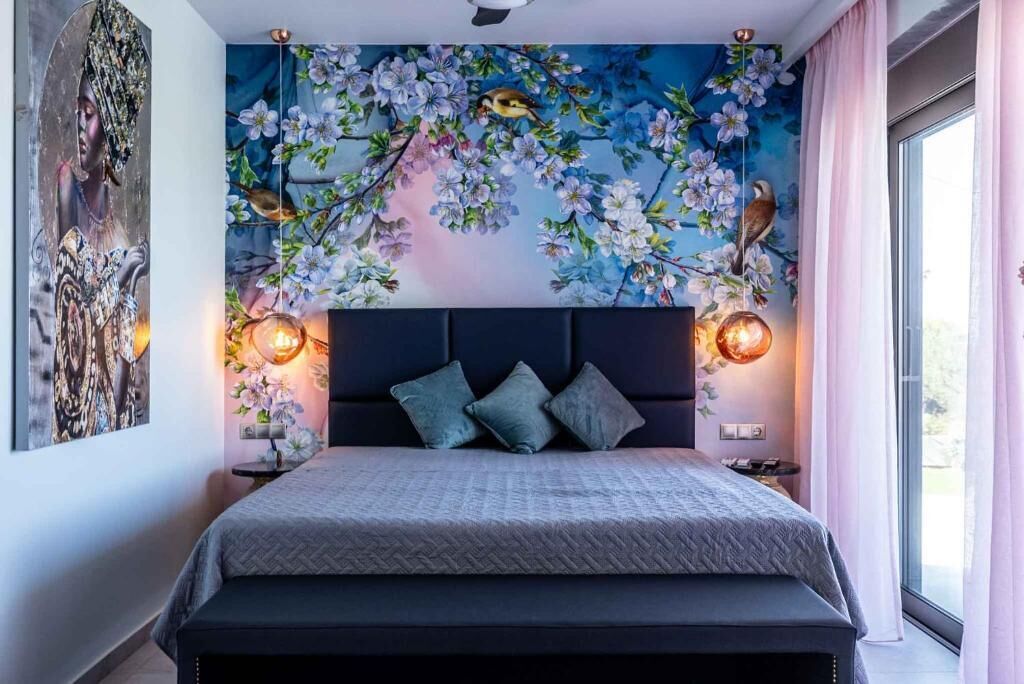 Un dormitorio moderno con una cama grande, un mural decorativo y vistas al exterior.