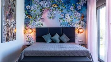 Un dormitorio moderno con una cama grande, un mural decorativo y vistas al exterior.