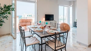 Un comedor espacioso con una mesa grande dispuesta para cuatro personas, rodeado de sillas.