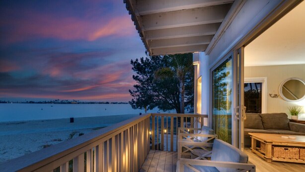 A wooden deck with a view of the beach and ocean at dusk. - Bayfront Oasis Near Boardwalk and Water (San Diego)