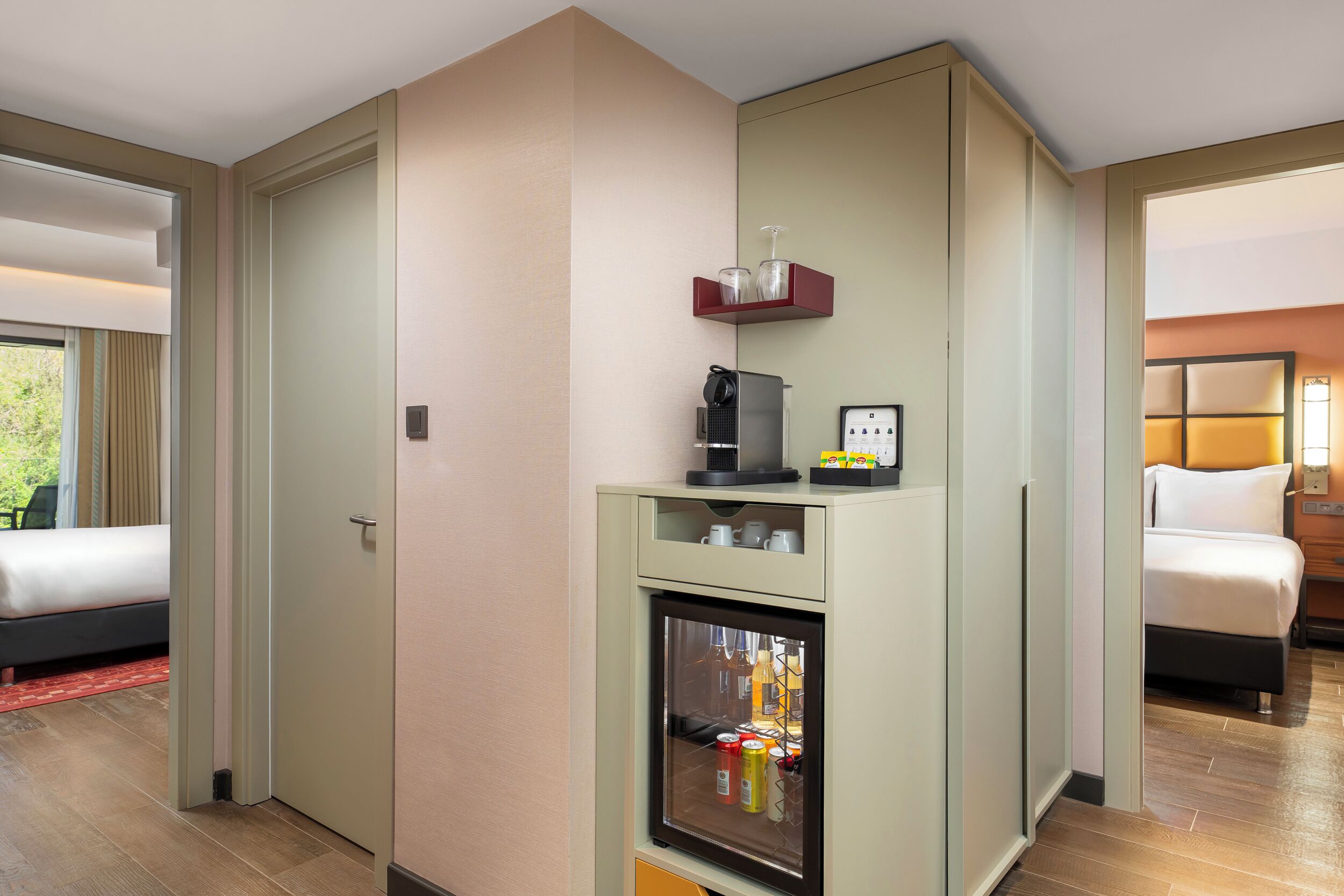 Una habitación de hotel con una cama, un minibar y un refrigerador pequeño.