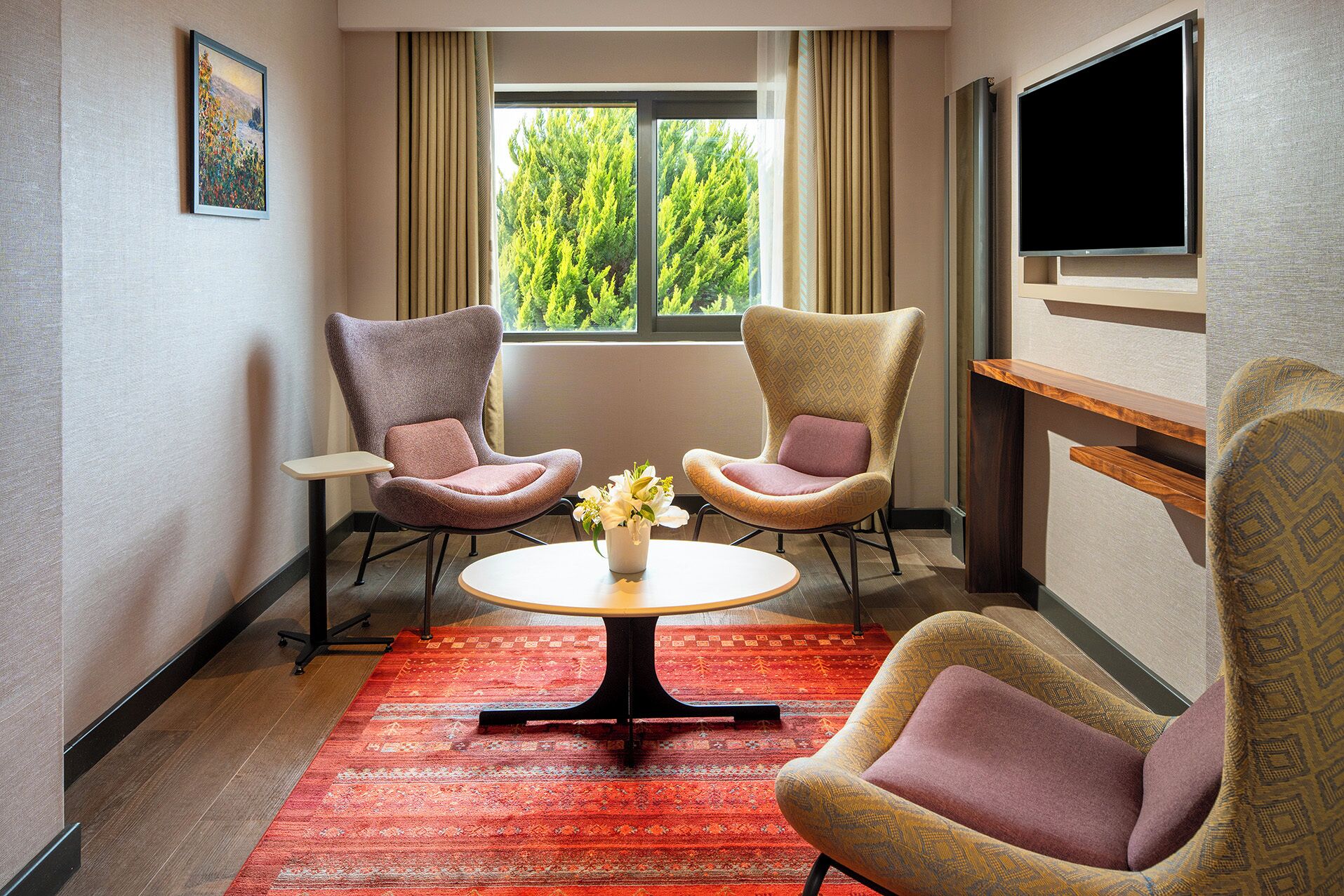 A room with two armchairs, a small table, and a TV.