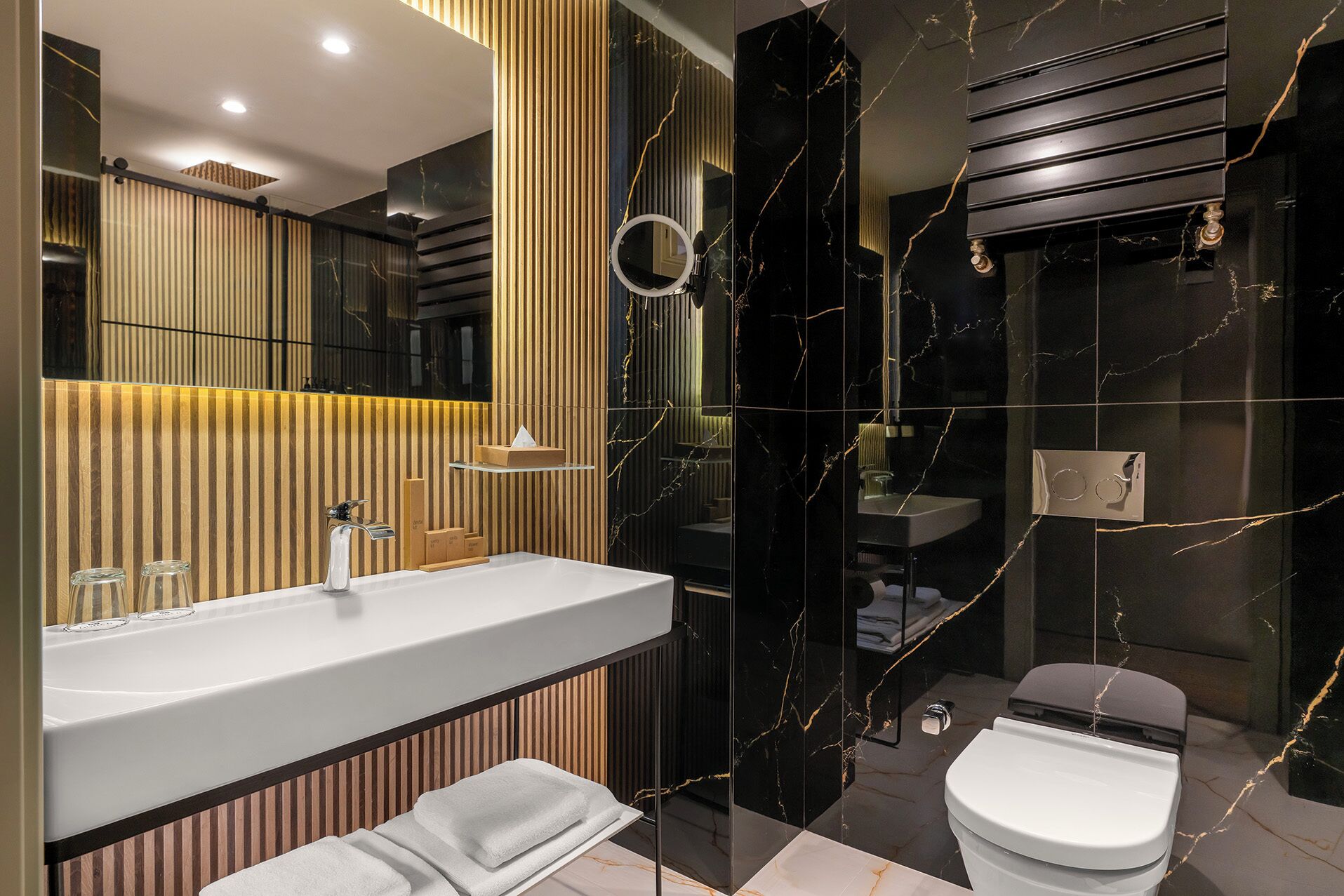 A modern bathroom with a vanity, mirror, and toilet.