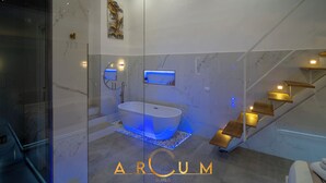 A modern bathroom with a freestanding bathtub, marble walls, and a glass-enclosed shower area. - ARCUM suites è situato nel cuore di Palermo ,non dovrai usare nessun mezzo  (Palermo)