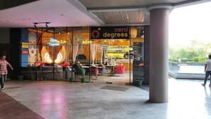 A storefront with a sign reading "Xero Degrees" and a colorful mural on the wall. - Luxury Deluxe Suite by Gt Studios (Greater Noida)