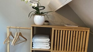 Ein Holzschrank mit Regalen, einer Kleiderstange und einer Bank.