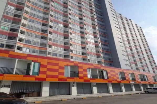 A high-rise building with multiple balconies and a colorful facade. - Capital O 93936 Tower Mahakam by Moii Kingdom (Cikarang)