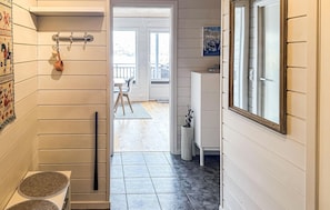A hallway with a wooden door, a small table with a mat, a potted plant, and a view of an outdoor balcony. - Awesome apartment in Tjørhom (Tjørhom)
